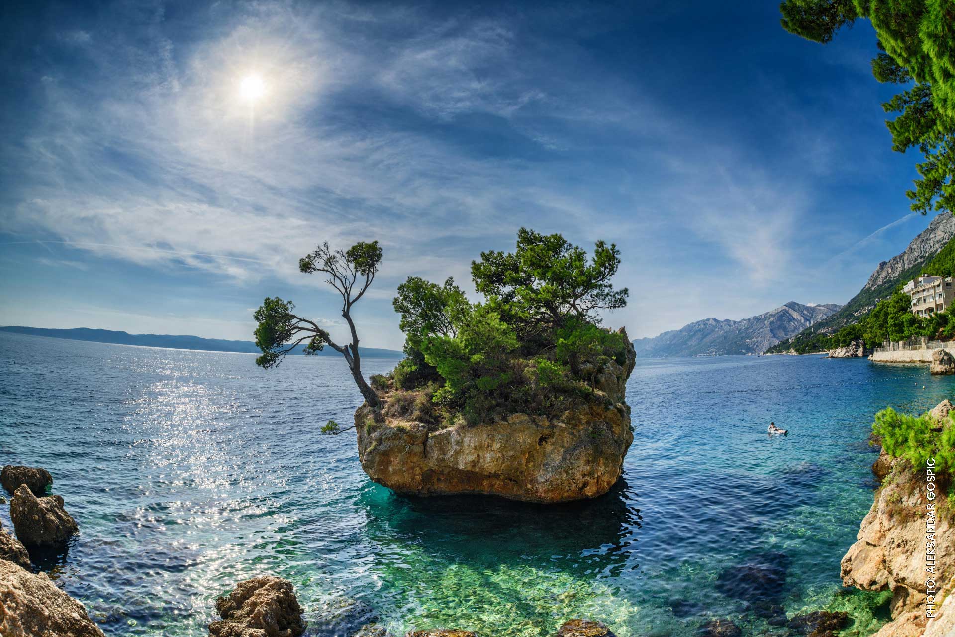 Big-stone-in-the-sea-Brela-Croatia rock with trees in the middle of the sea