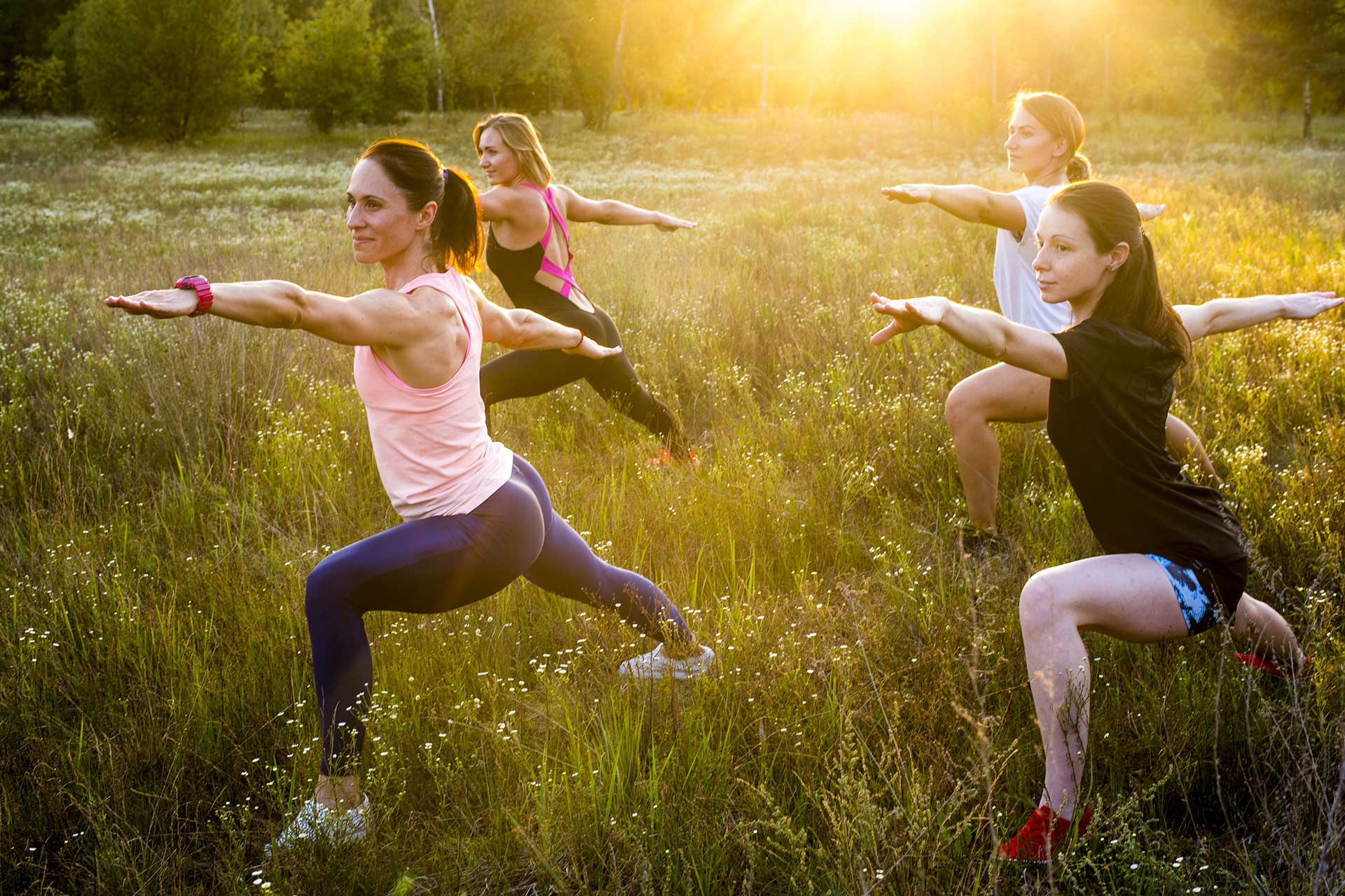 four women stretching in a nature