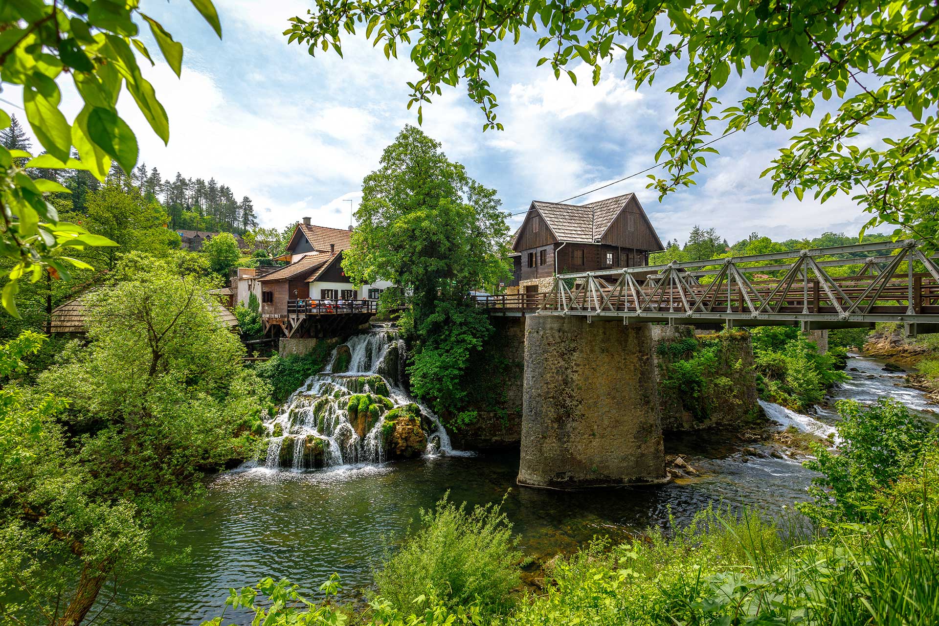 houses next to the river and waterfalls